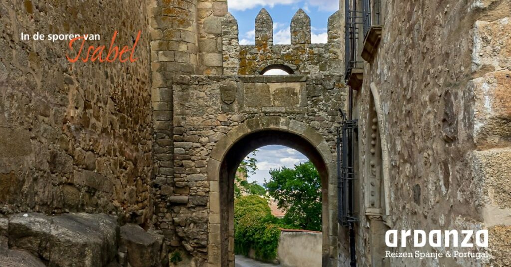 Medieval stone archway between rough stone walls, with Dutch headline 'In de sporen van Isabel' and Ardanza Reizen branding in the corner.